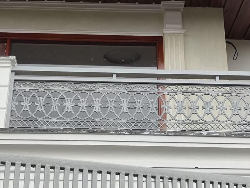 Cast metal balcony railing with lattice panels